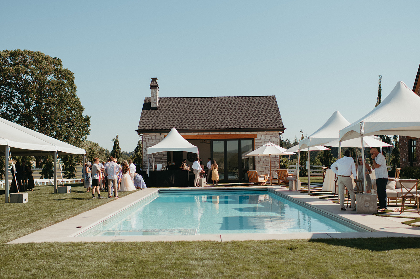 Outdoor private property wedding, cocktail reception around a pool. Backyard wedding with pool